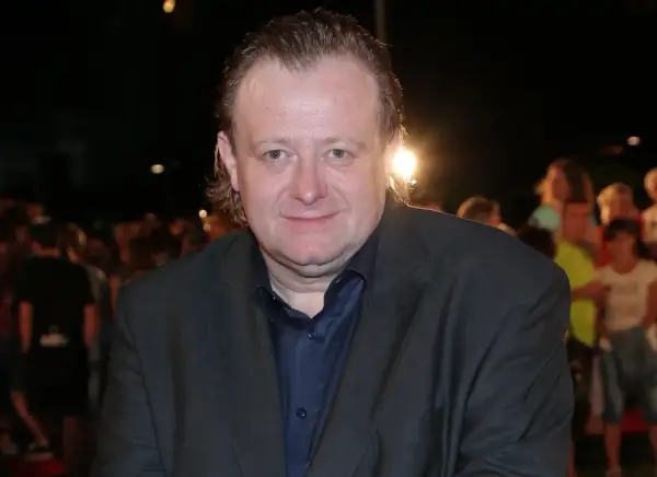 Grzegorz Warchoł w garniturze, na tle tłumu.