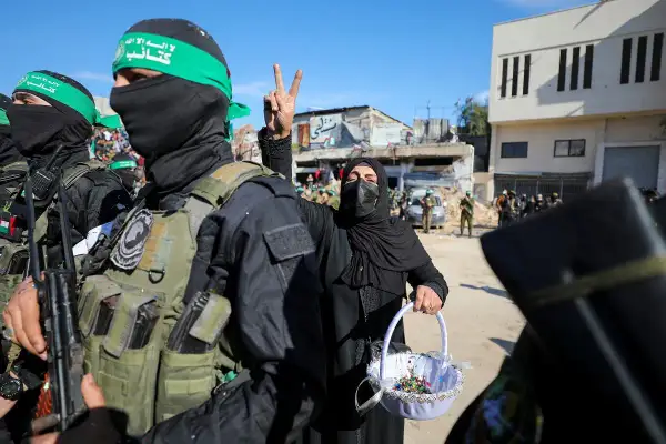 Kobieta z koszykiem i symbolem zwycięstwa obok uzbrojonych mężczyzn. Może to być symbol nadziei na lepsze jutro, gdzie trzy dni i jedno życie nabierają nowego znaczenia.