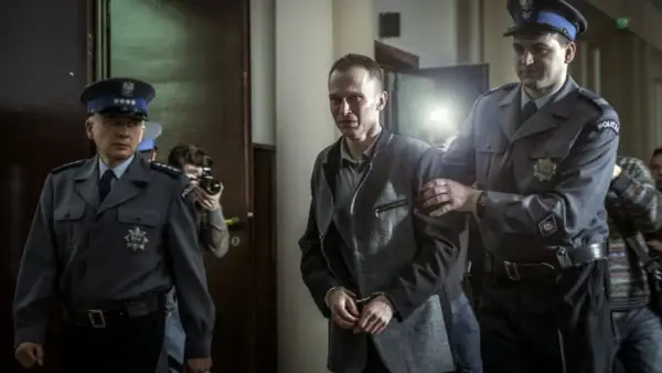 Tomek Komenda, skuty kajdankami, prowadzony przez policjantów. Historia o 25 latach niewinności.
